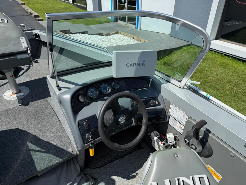 Slide: The Image of 2005 Lund 1700 Fisherman boat dashboard with Garmin GPS, steering wheel, and control panel. - 11