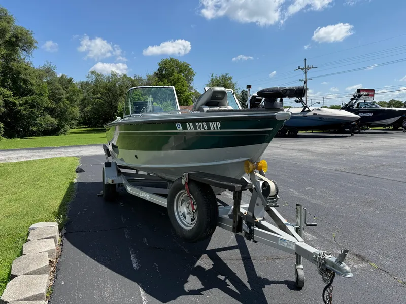 Slide: The Image of 2005 Lund 1700 Fisherman boat on trailer, parked outdoors under a clear blue sky. - 4