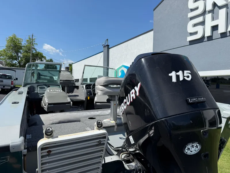 Slide: The Image of 2005 Lund 1700 Fisherman boat with Mercury 115 engine, parked near a building. - 5