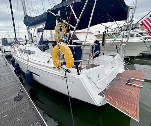 Slide: The Image of 2018 Jeanneau Sun Odyssey 389 sailboat docked, featuring a spacious deck and safety equipment. - 2