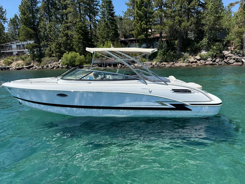 Slide: The Image of 2013 Formula 290 Bowrider boat on clear water, surrounded by trees and shoreline. - 1