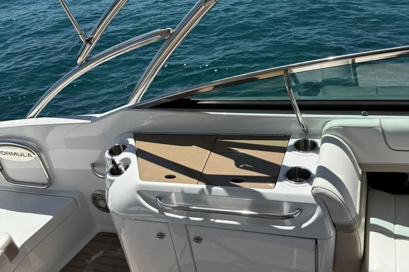 Slide: The Image of 2013 Formula 290 Bowrider boat interior with cup holders and seating, on a sunny day. - 13