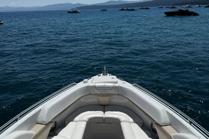 Slide: The Image of 2013 Formula 290 Bowrider on a serene lake with distant boats and mountains. - 7