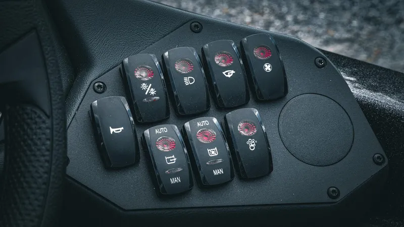 Slide: The Image of Control panel of 2026 Skeeter ZXE 20 boat with various switches and indicators. - 23