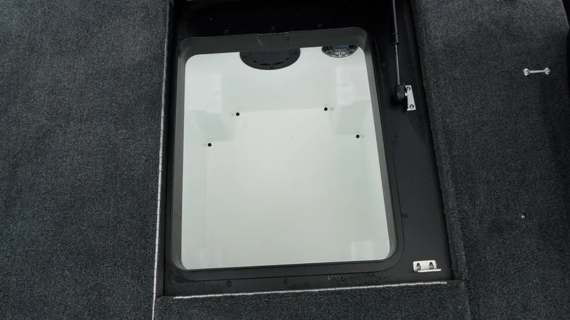 Slide: The Image of 2026 Skeeter ZXE 20 boat storage compartment with carpeted interior and secure latch. - 28