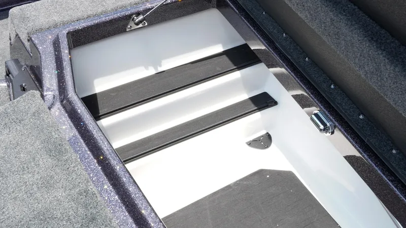 Slide: The Image of 2026 Skeeter ZXE 20 boat storage compartment with carpeted interior and secure latch. - 38