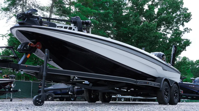 Slide: The Image of 2026 Skeeter ZXE 20 boat on trailer, parked outdoors with trees in background. - 47