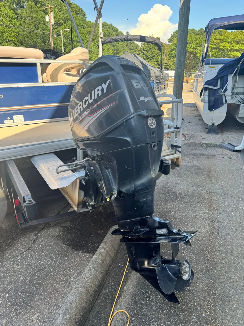 Slide: The Image of 2014 Sun Tracker Party Barge 20 DLX with Mercury outboard motor, docked outdoors. - 2