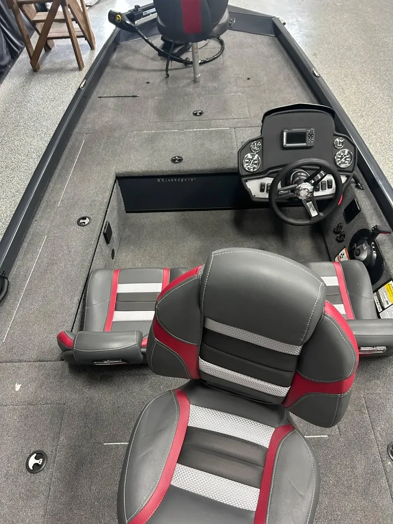 Slide: The Image of 2022 Ranger RT178C boat interior with steering wheel, gauges, and red-accented seats. - 13