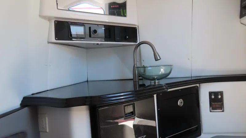 Slide: The Image of Modern MTI 42V boat interior with sleek kitchenette, glass sink, and advanced control panel, 2020 model. - 12