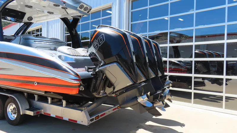 Slide: The Image of 2020 MTI 42V boat with quad outboard engines on a trailer, reflecting in glass doors. - 2
