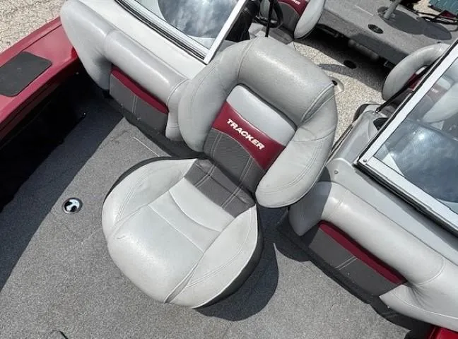 Slide: The Image of 2015 Tracker Targa V-18 Combo boat seat, gray and red upholstery, on deck. - 11