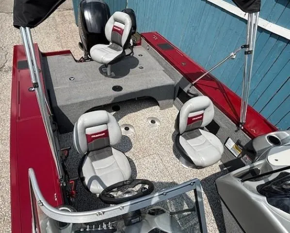 Slide: The Image of 2015 Tracker Targa V-18 Combo boat with red and gray seating, steering wheel, and fishing setup. - 23