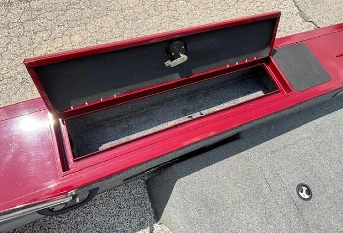 Slide: The Image of Open storage compartment on 2015 Tracker Targa V-18 Combo boat, red exterior, gray interior. - 25