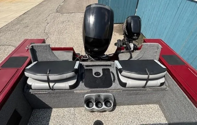 Slide: The Image of 2015 Tracker Targa V-18 Combo boat interior with dual seats and motor, docked near blue wall. - 29