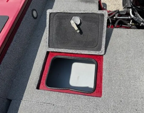 Slide: The Image of 2015 Tracker Targa V-18 Combo boat storage compartment with open lid and key. - 33