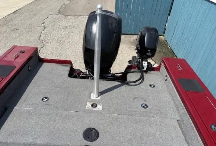 Slide: The Image of 2015 Tracker Targa V-18 Combo boat deck with motor, red accents, and blue fence background. - 34