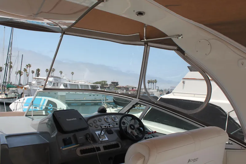 Slide: The Image of 2005 Cruisers Yachts 370 Express helm with marina view and palm trees. - 12
