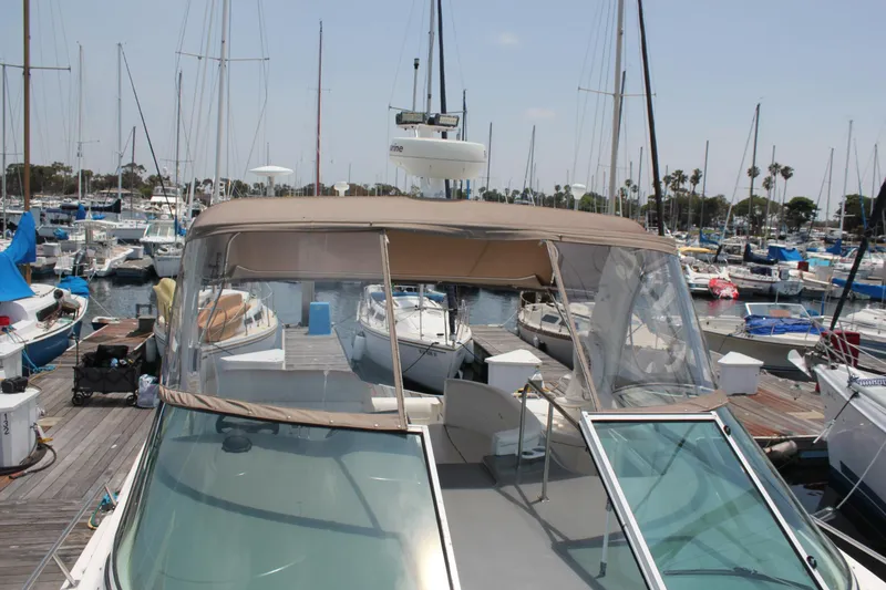 Slide: The Image of 2005 Cruisers Yachts 370 Express docked in a marina, surrounded by sailboats. - 13