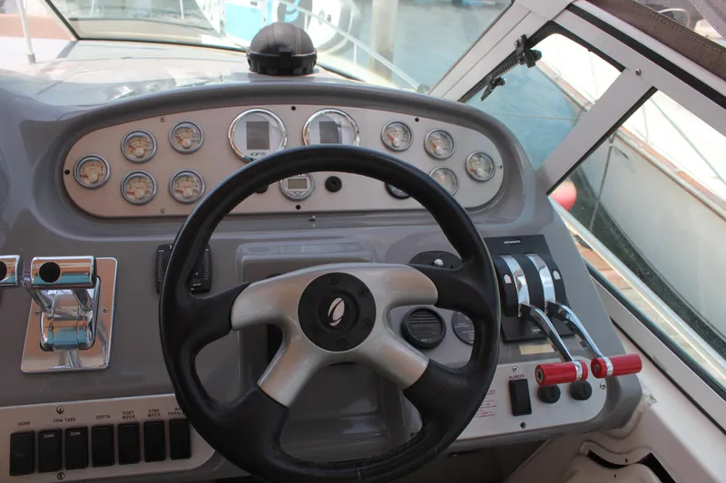 Slide: The Image of 2005 Cruisers Yachts 370 Express helm with steering wheel and control panel. - 19