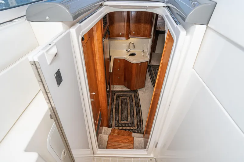 Slide: The Image of 2005 Cruisers Yachts 370 Express interior with wood cabinetry and compact kitchenette. - 20