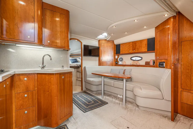 Slide: The Image of Luxurious 2005 Cruisers Yachts 370 Express interior with wood cabinetry and cozy seating area. - 21