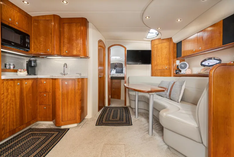 Slide: The Image of Luxurious 2005 Cruisers Yachts 370 Express interior with wood cabinetry and cozy seating area. - 27