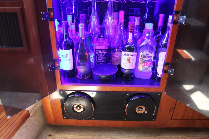 Slide: The Image of Bar cabinet with assorted liquor bottles and speakers on a 2005 Cruisers Yachts 370 Express. - 28