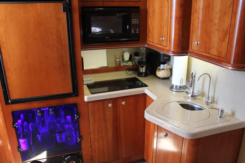 Slide: The Image of Luxurious 2005 Cruisers Yachts 370 Express kitchen with wood cabinetry and modern appliances. - 31