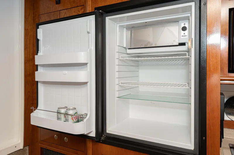Slide: The Image of Open refrigerator inside 2005 Cruisers Yachts 370 Express, containing canned drinks. - 34