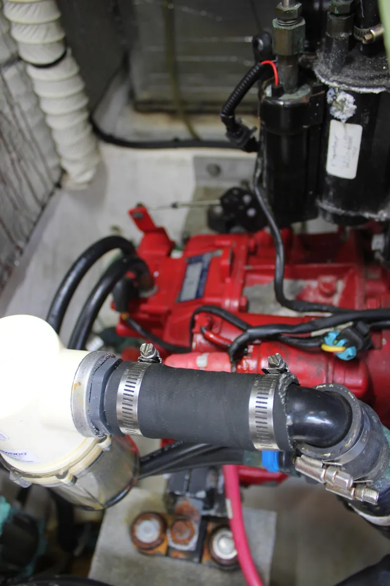 Slide: The Image of Engine compartment of 2005 Cruisers Yachts 370 Express, featuring red engine components and hoses. - 46