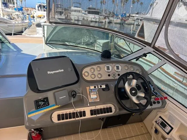 Slide: The Image of 2005 Cruisers Yachts 370 Express helm with navigation equipment and steering wheel at marina. - 49