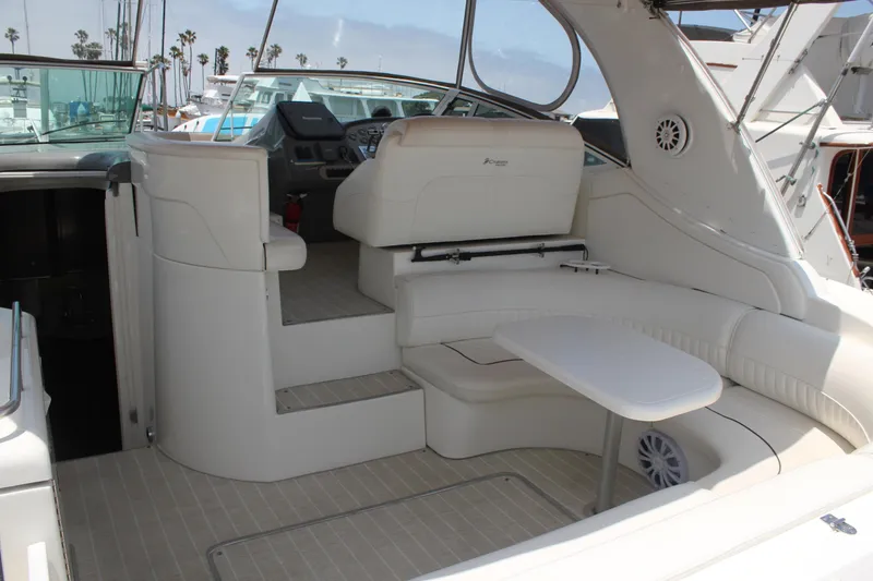Slide: The Image of 2005 Cruisers Yachts 370 Express interior with white seating and table, docked at marina. - 8