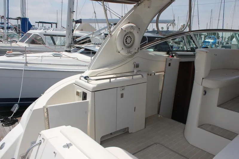 Slide: The Image of 2005 Cruisers Yachts 370 Express interior with seating and storage, docked at marina. - 9