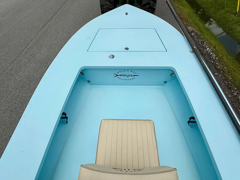 Slide: The Image of 2021 Hell's Bay Marquesa boat interior with light blue deck and beige seat. - 12