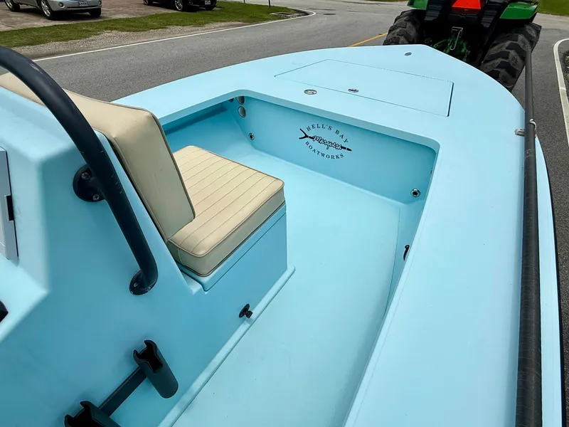 Slide: The Image of 2021 Hell's Bay Marquesa boat interior with seating, parked on a road. - 13