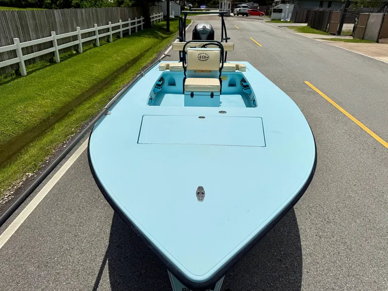 Slide: The Image of 2021 Hell's Bay Marquesa boat on road, light blue deck, white fence background. - 6