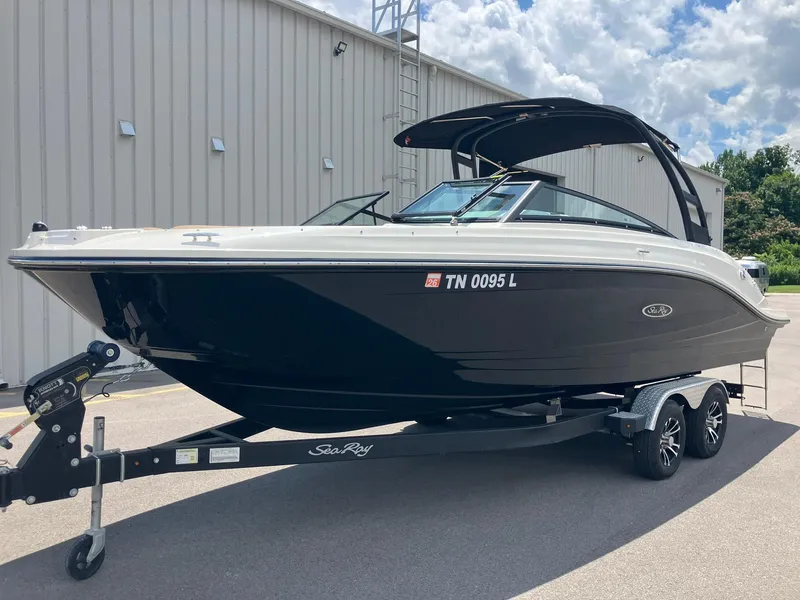 Slide: The Image of 2023 Sea Ray SPX 230 boat on trailer, parked outdoors under a cloudy sky. - 0