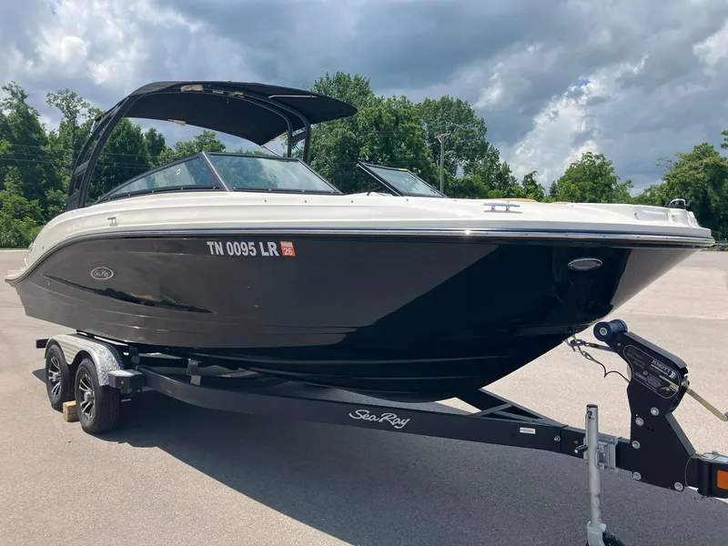 Slide: The Image of 2023 Sea Ray SPX 230 boat on trailer, parked outdoors under cloudy sky. - 1