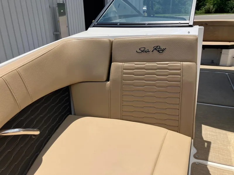 Slide: The Image of 2023 Sea Ray SPX 230 boat interior with beige seating and logo detail. - 11