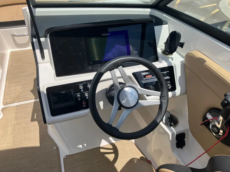 Slide: The Image of 2023 Sea Ray SPX 230 boat dashboard with steering wheel and navigation controls. - 14
