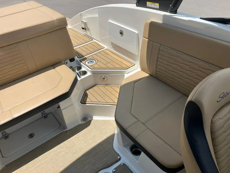 Slide: The Image of 2023 Sea Ray SPX 230 boat interior with tan seating and wood accents. - 16