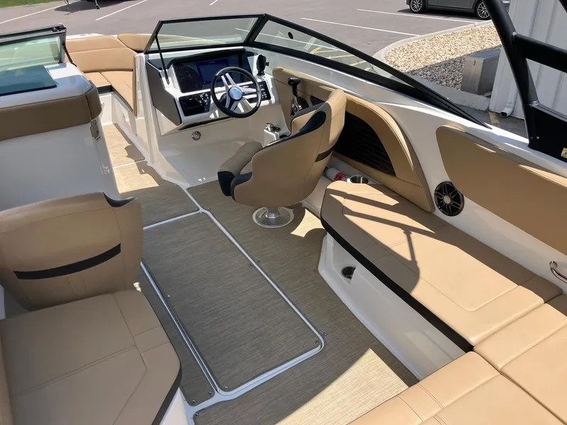 Slide: The Image of 2023 Sea Ray SPX 230 boat interior with beige seating and modern dashboard. - 18