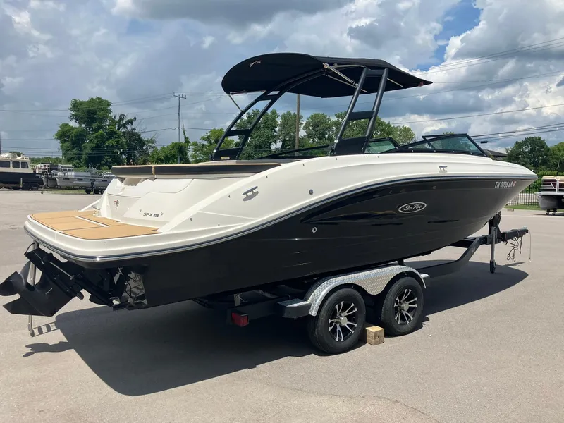 Slide: The Image of 2023 Sea Ray SPX 230 boat on trailer under cloudy sky. - 2