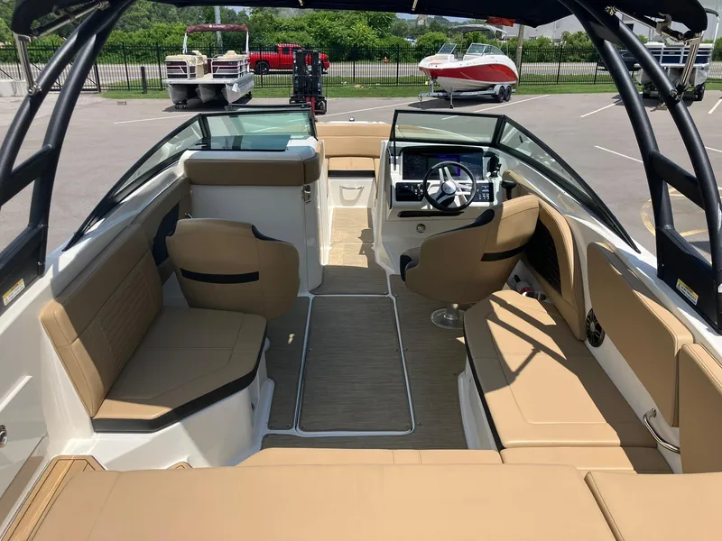 Slide: The Image of 2023 Sea Ray SPX 230 boat interior with tan seating and modern dashboard. - 5