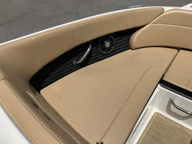 Slide: The Image of 2023 Sea Ray SPX 230 boat interior with tan seating and stainless steel accents. - 9
