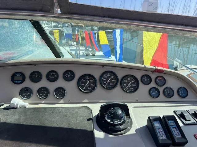 Slide: The Image of Dashboard of a 1990 Donzi 300 Levante boat with nautical flags in the background. - 11
