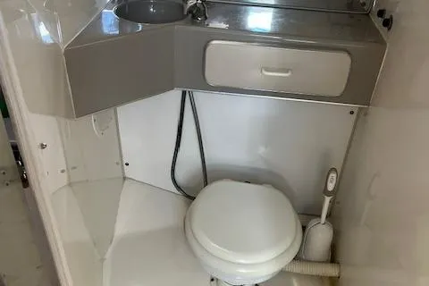 Slide: The Image of Bathroom interior of a 1990 Donzi 300 Levante boat, featuring a toilet and sink. - 15