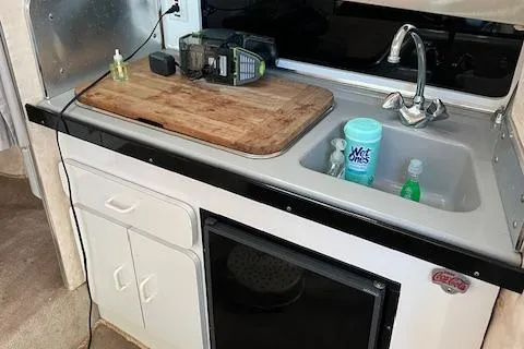 Slide: The Image of Compact kitchen area in a 1990 Donzi 300 Levante boat, featuring a sink and storage. - 16