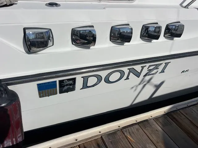 Slide: The Image of Side view of a 1990 Donzi 300 Levante boat docked at a marina. - 8